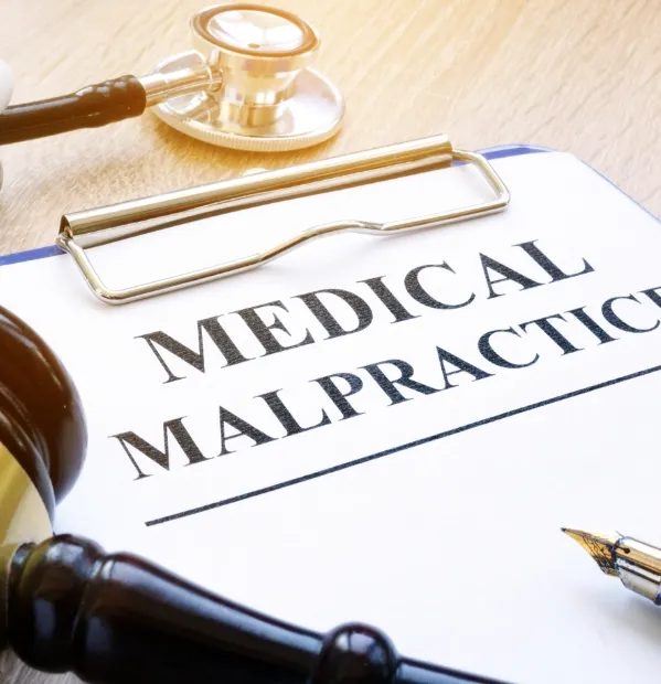 clip board with paper that says "medical malpractice" on it.