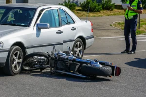 A motorcycle that has been hit and damaged by a car in a motorcycle accident.