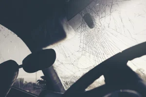 The shattered windshield of a car in an accident. The driver is curious whether they can still receive compensation if they were partially at fault.