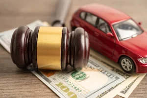 A toy car with a gavel and money signifying an insurance claim after a rideshare accident in Texas.