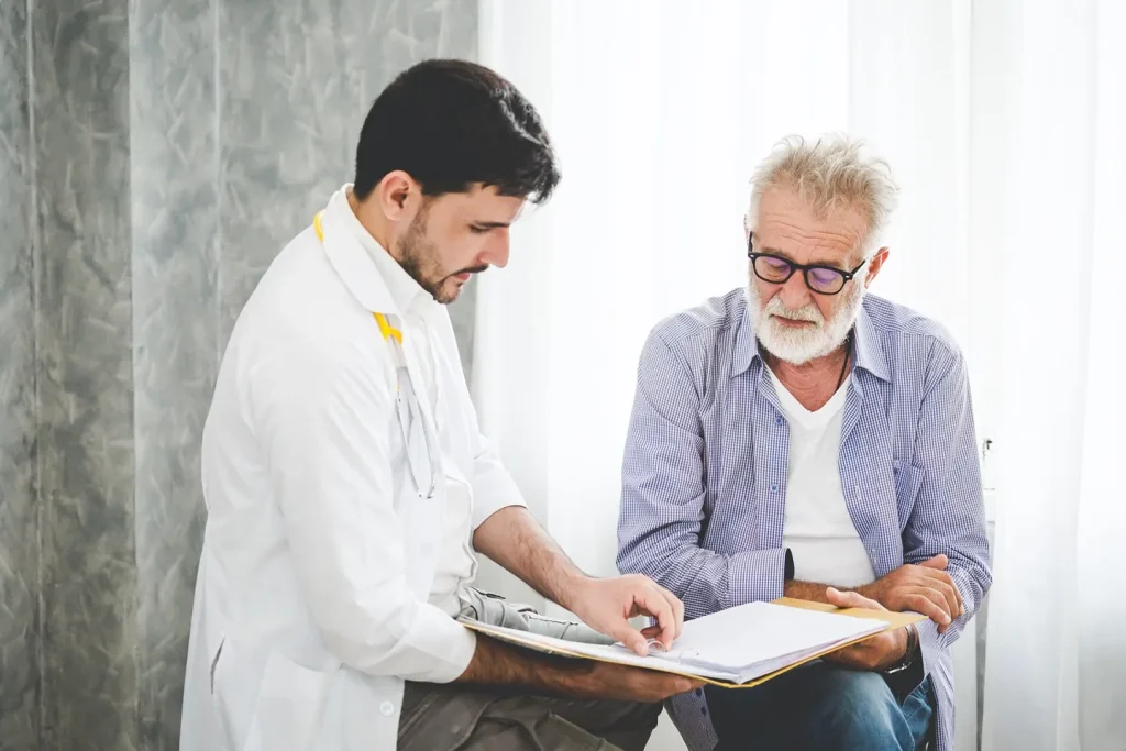 An elderly man speaking with a doctor.