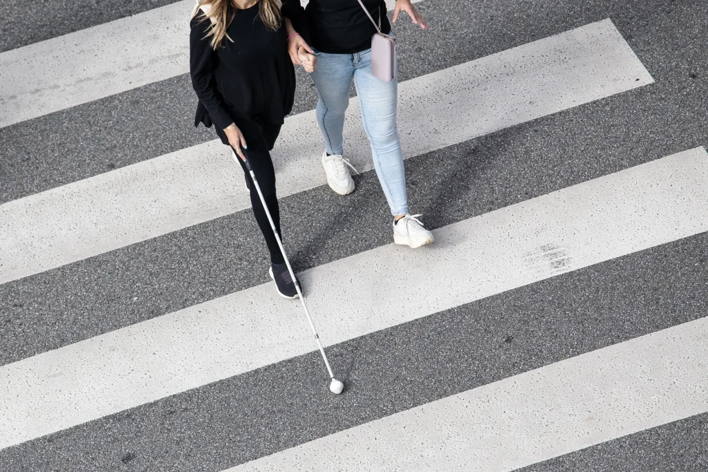 Blind woman crossing the street.