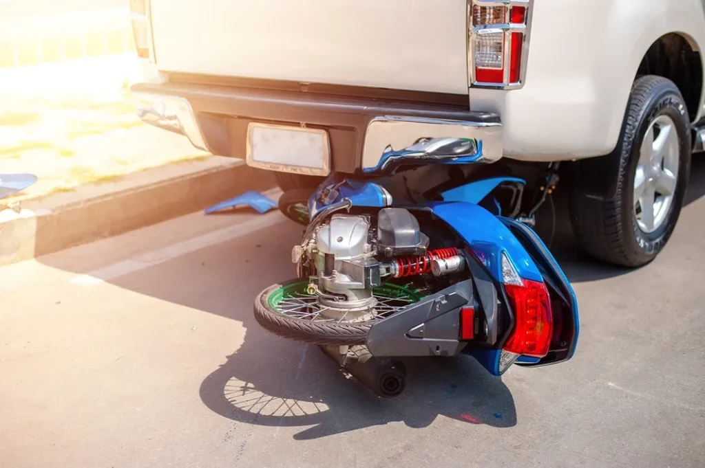 Motorcycle under a truck.